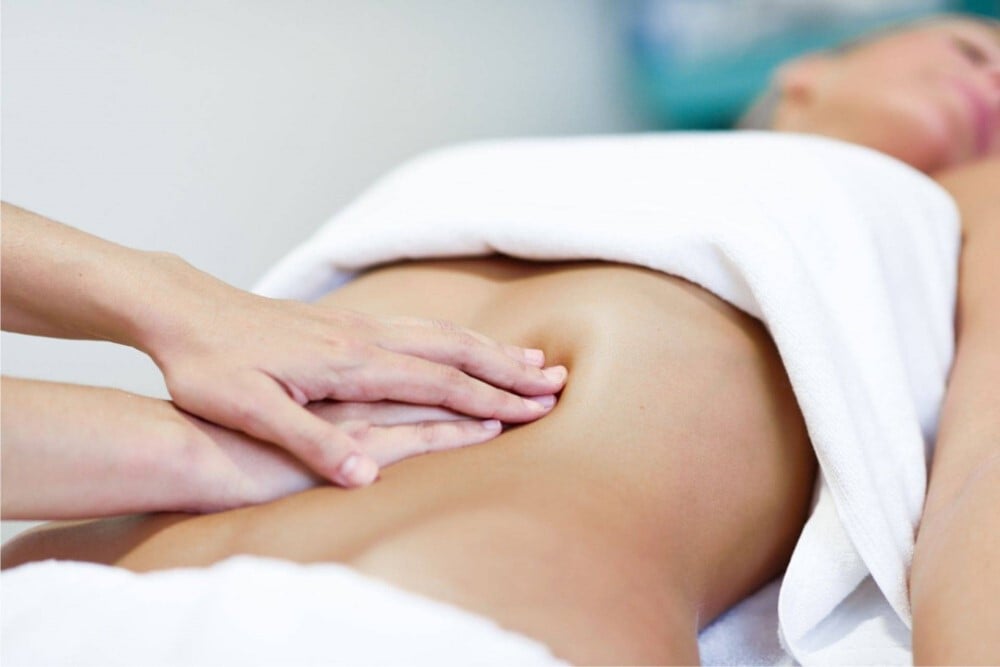 Massage vùng bụng nhẹ nhàng cùng tinh dầu để xoa dịu cơn đau bụng kinh